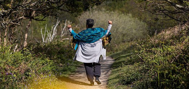 woman walking in the woods with enthusiasm