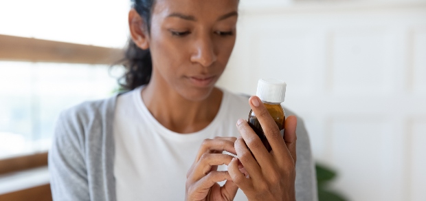 woman looking at a prescription bottle