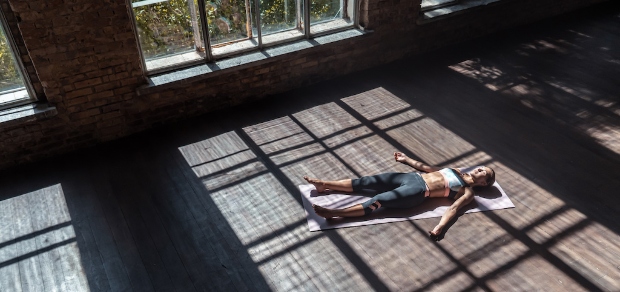 woman laying on the floor with the sun streaming through the windows