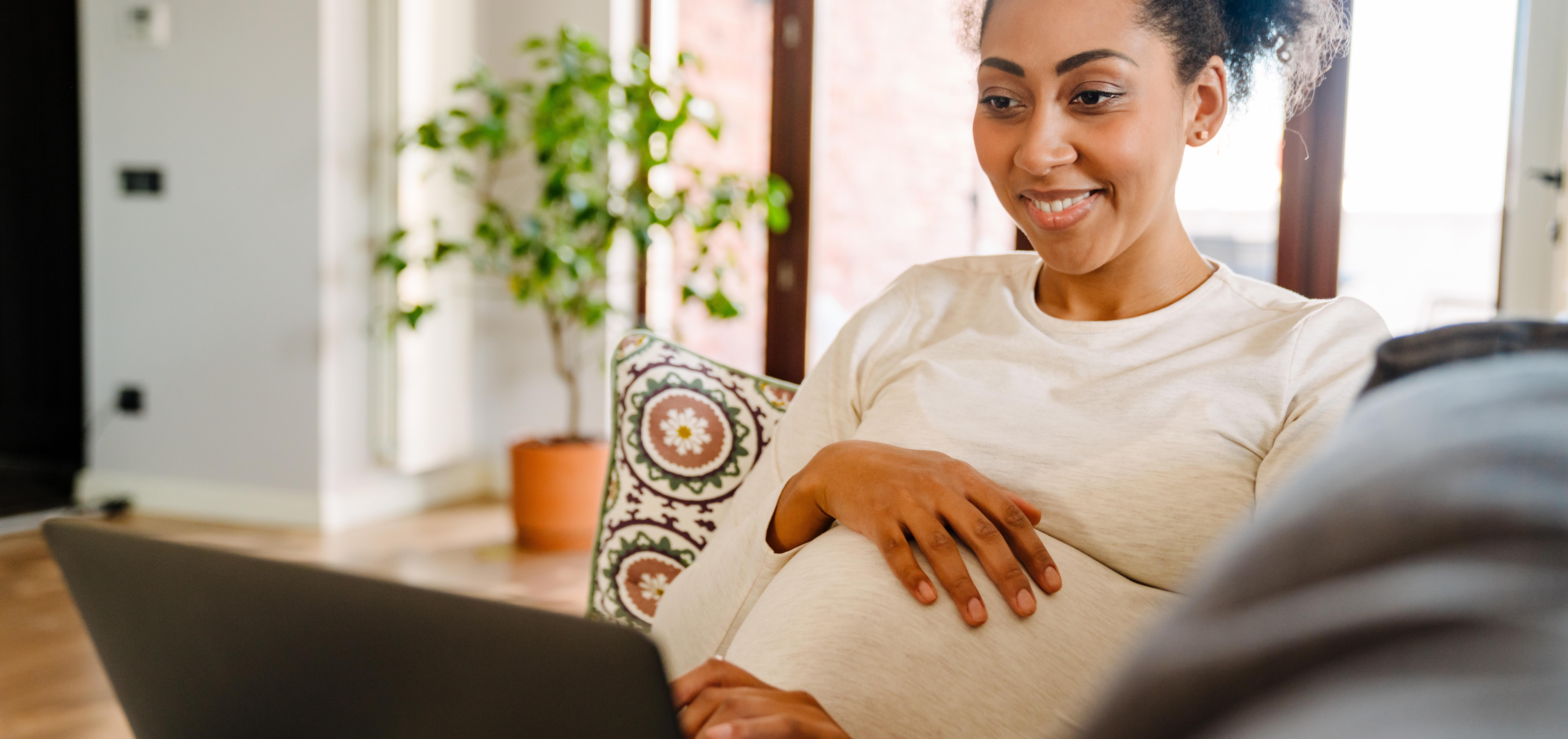 pregnant woman looking at birth plan examples on her laptop