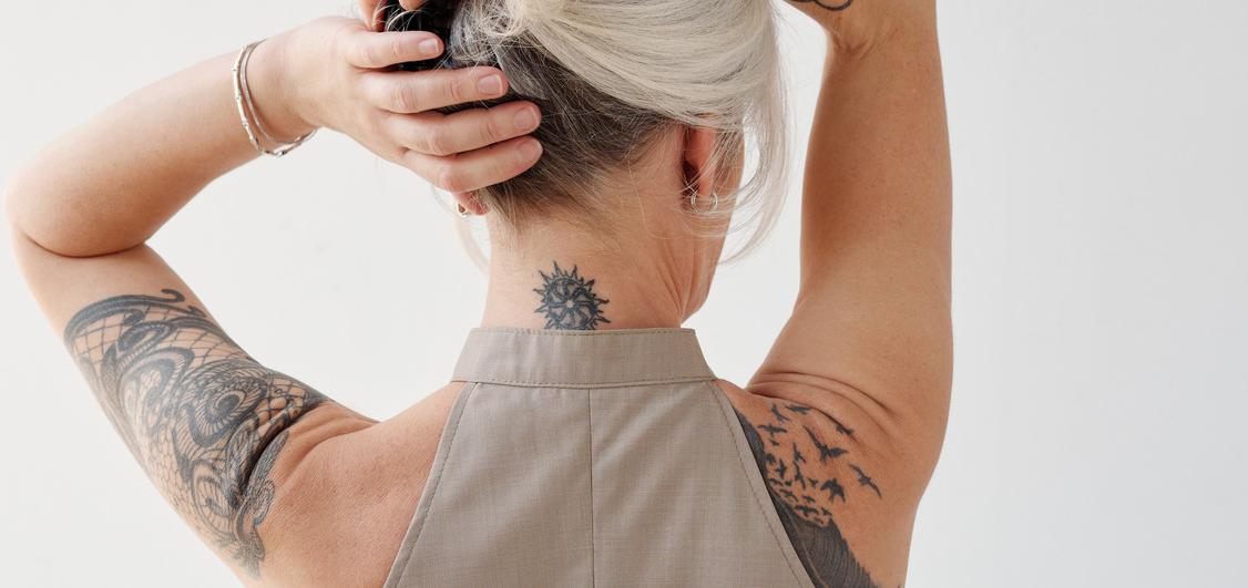 Woman with gray hair and beautiful tattoos. 