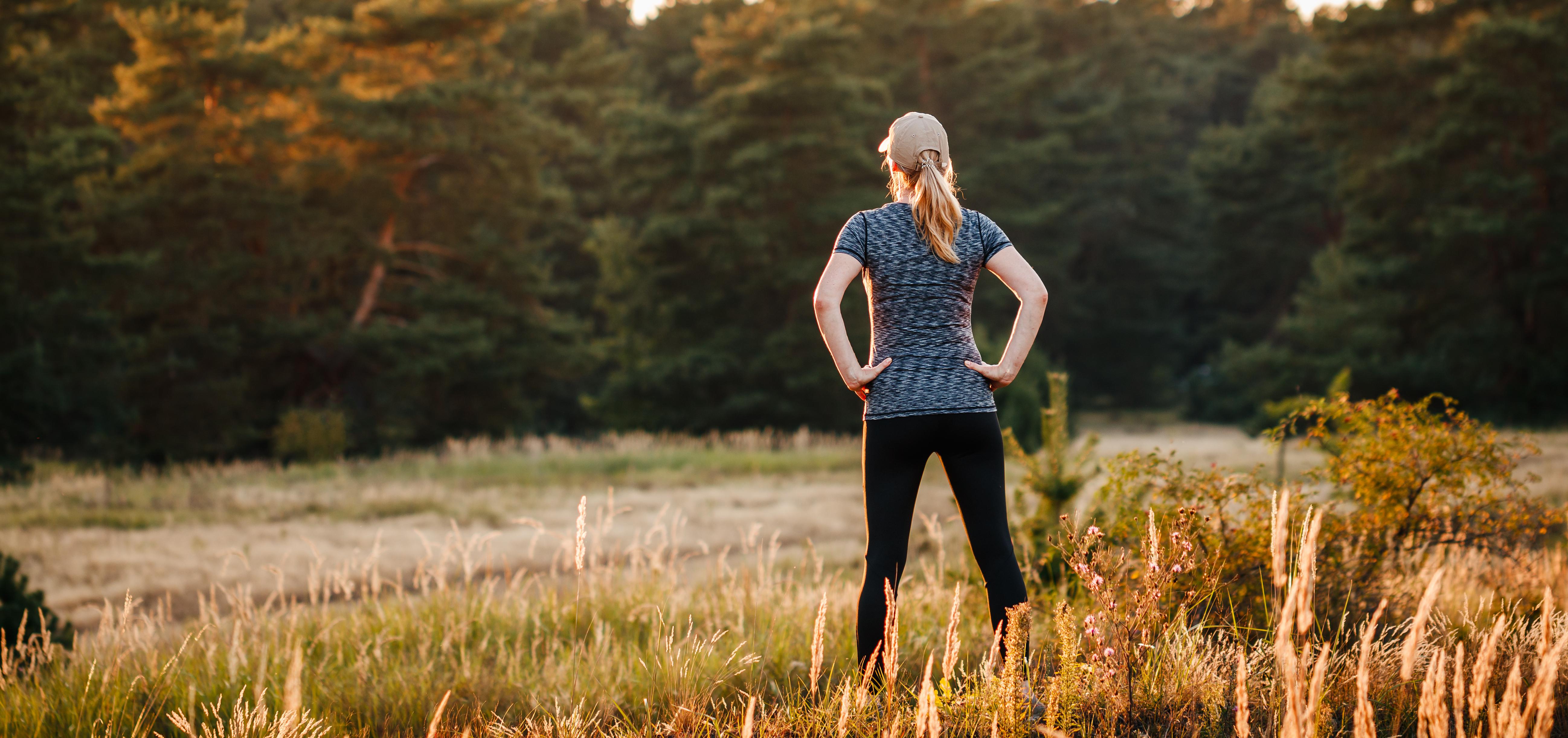 Woman standing outdoors with hands on hips