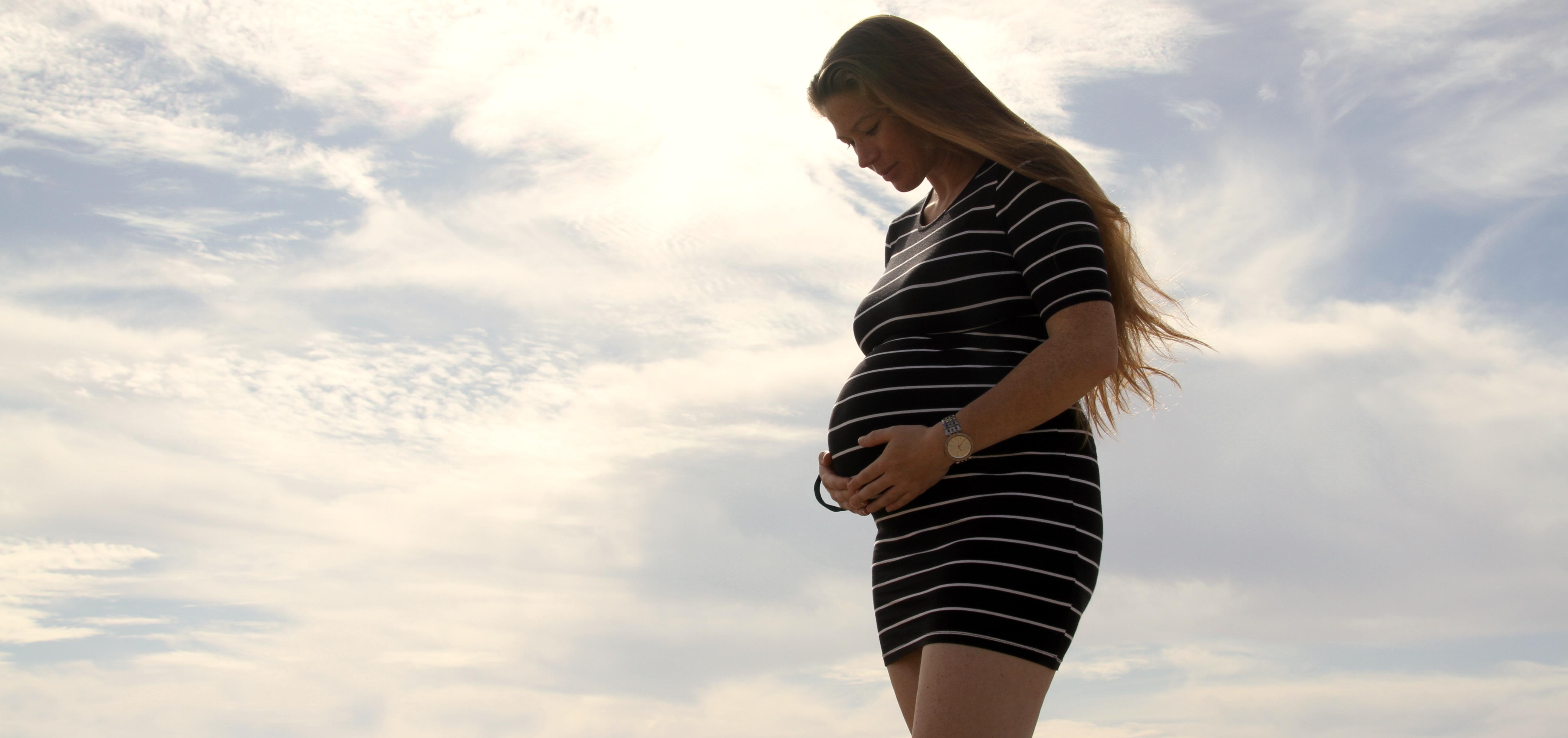 woman cradling her pregnant stomach