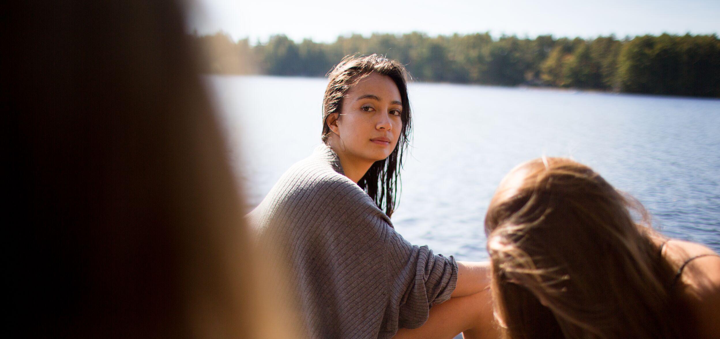 Young woman in a boat looking envious of her friends