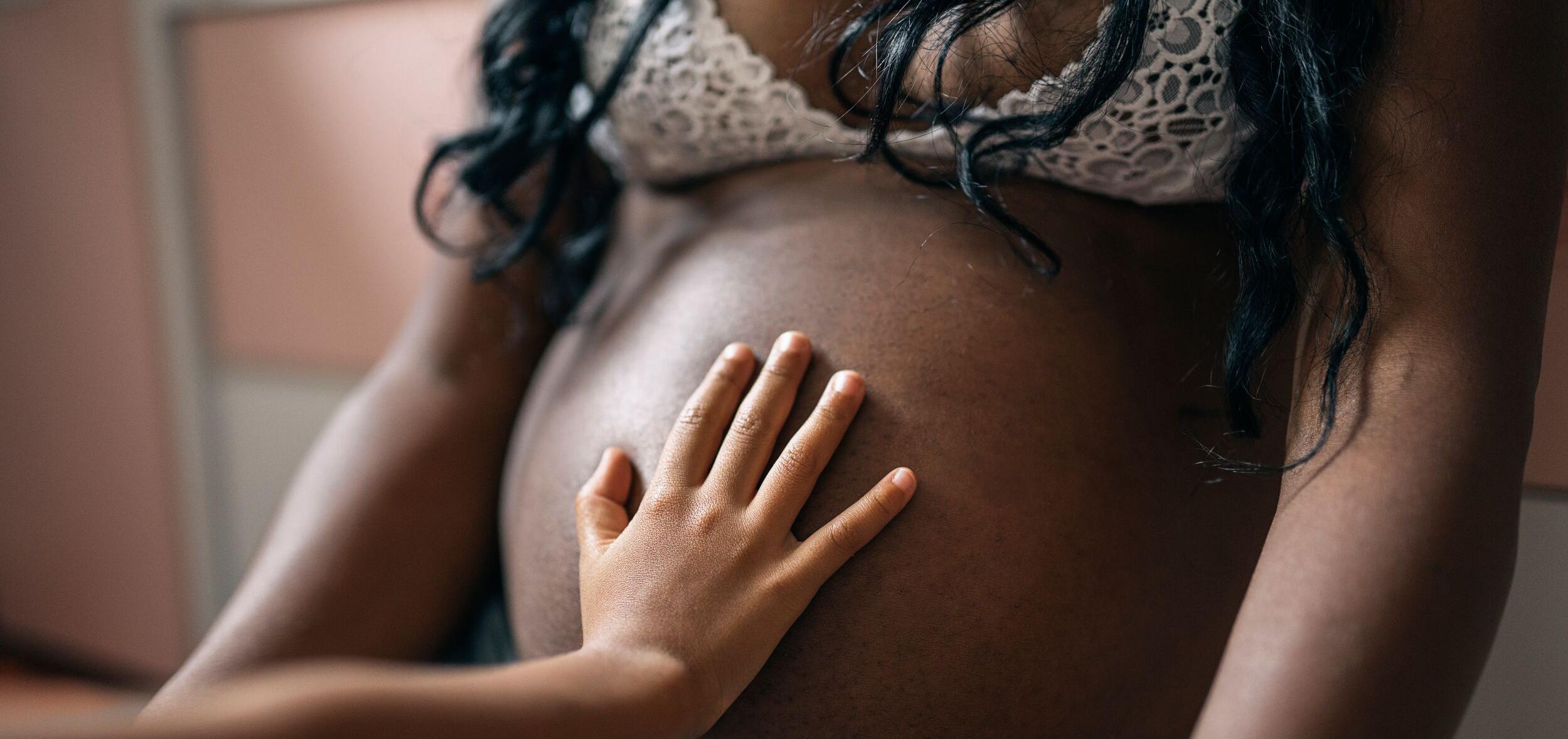 hand pressed on pregnant woman's belly