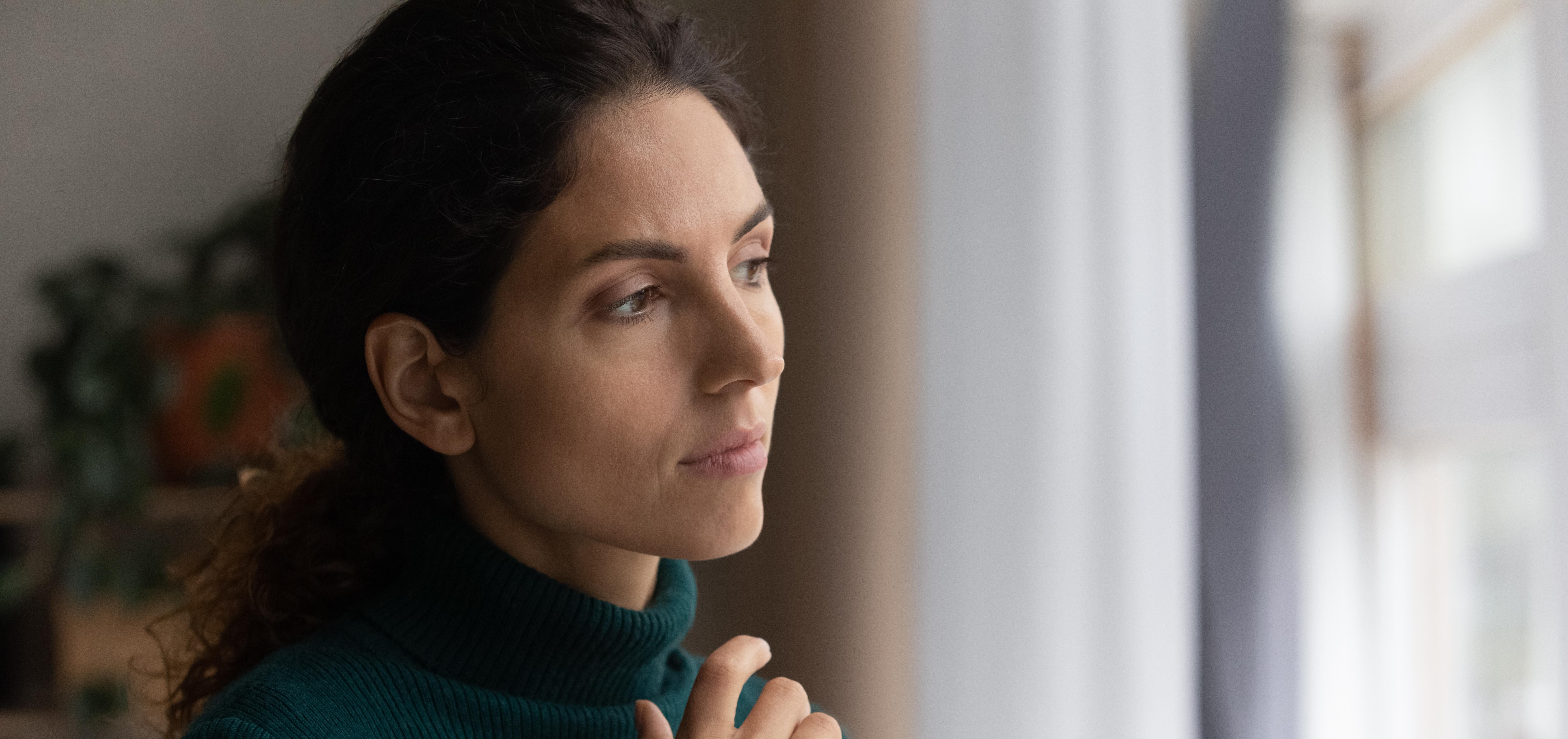 lonely woman looking out the window