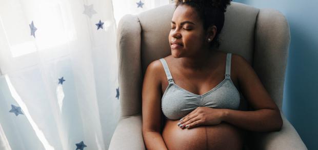 Calm pregnant woman sitting by a window