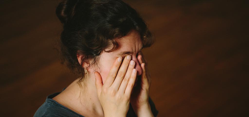 woman rubbing her eyes