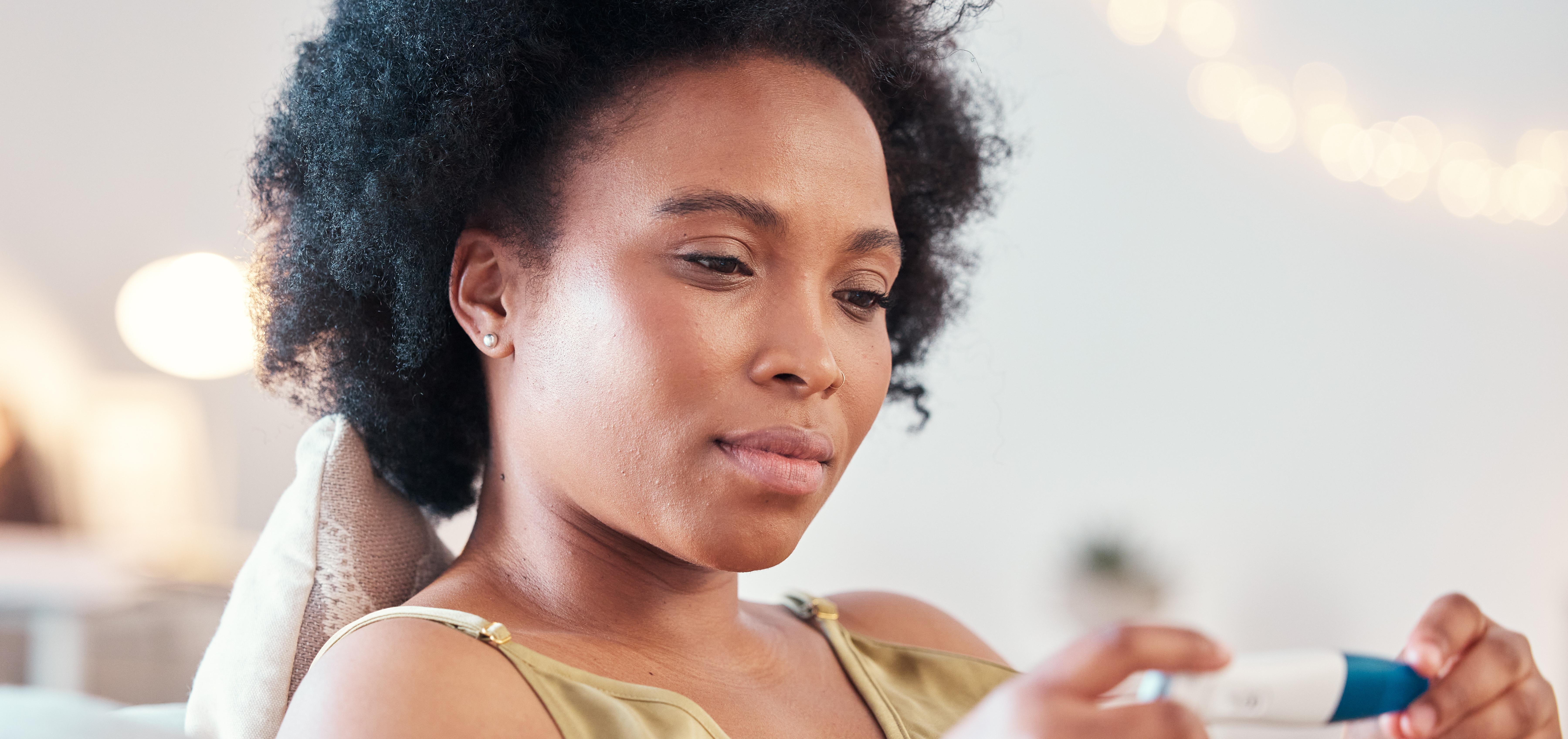 woman looking at an at-home pregnancy test