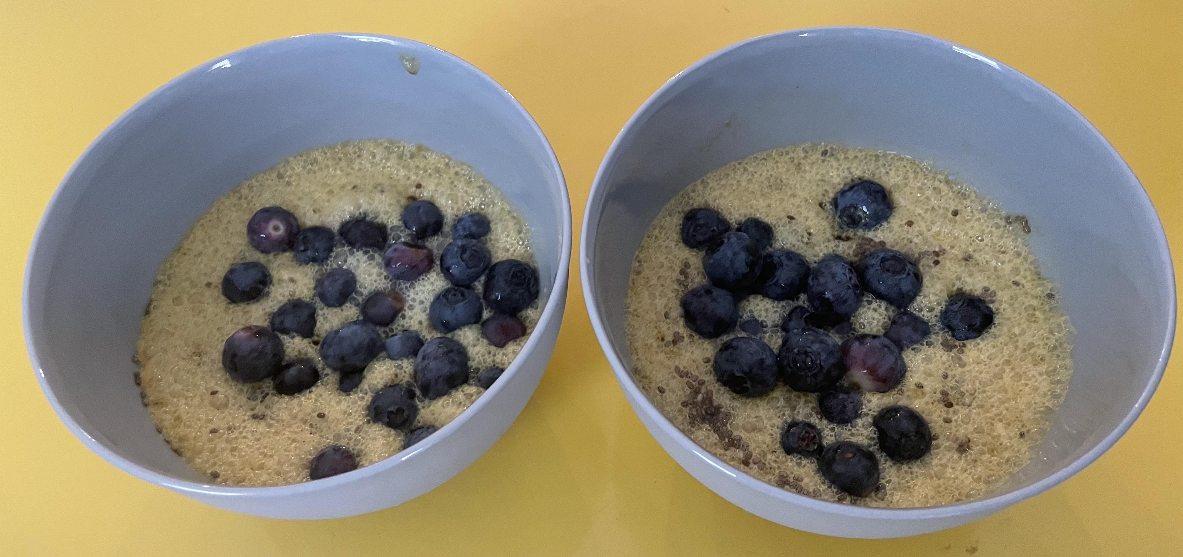 Spoonful of golden milk chia pudding topped with large blueberries