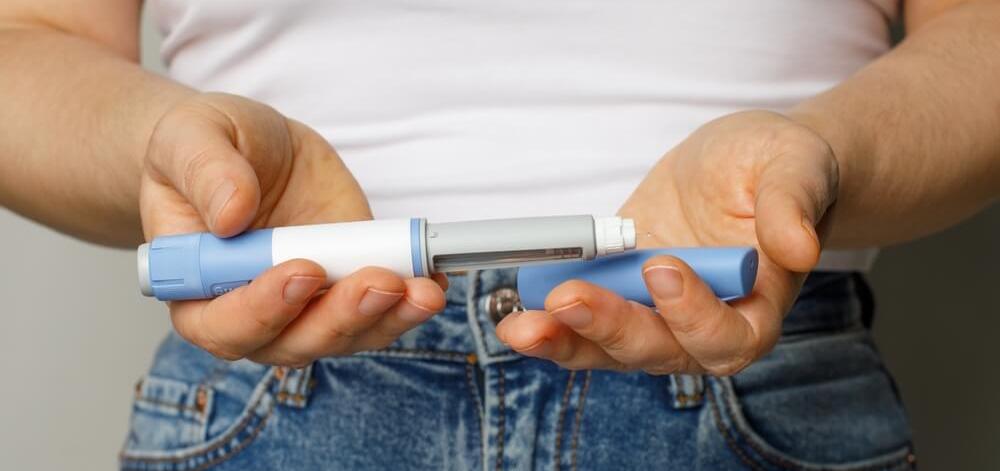 person holding a GLP-1 medication injection pen