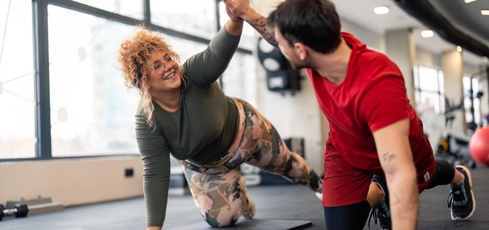 man and a woman at a fitness center exercising