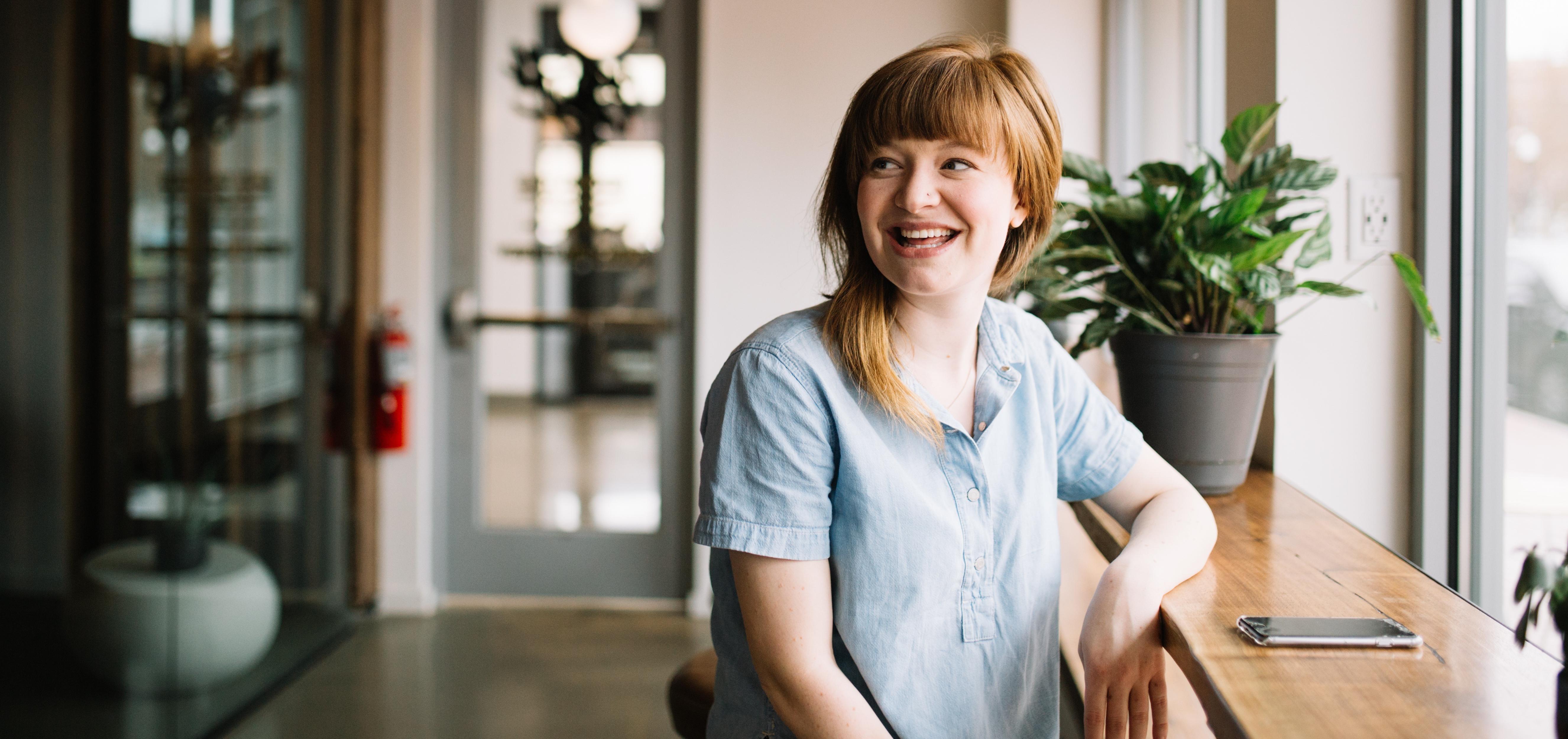 A woman looking off to the distance with a wide smile on her face