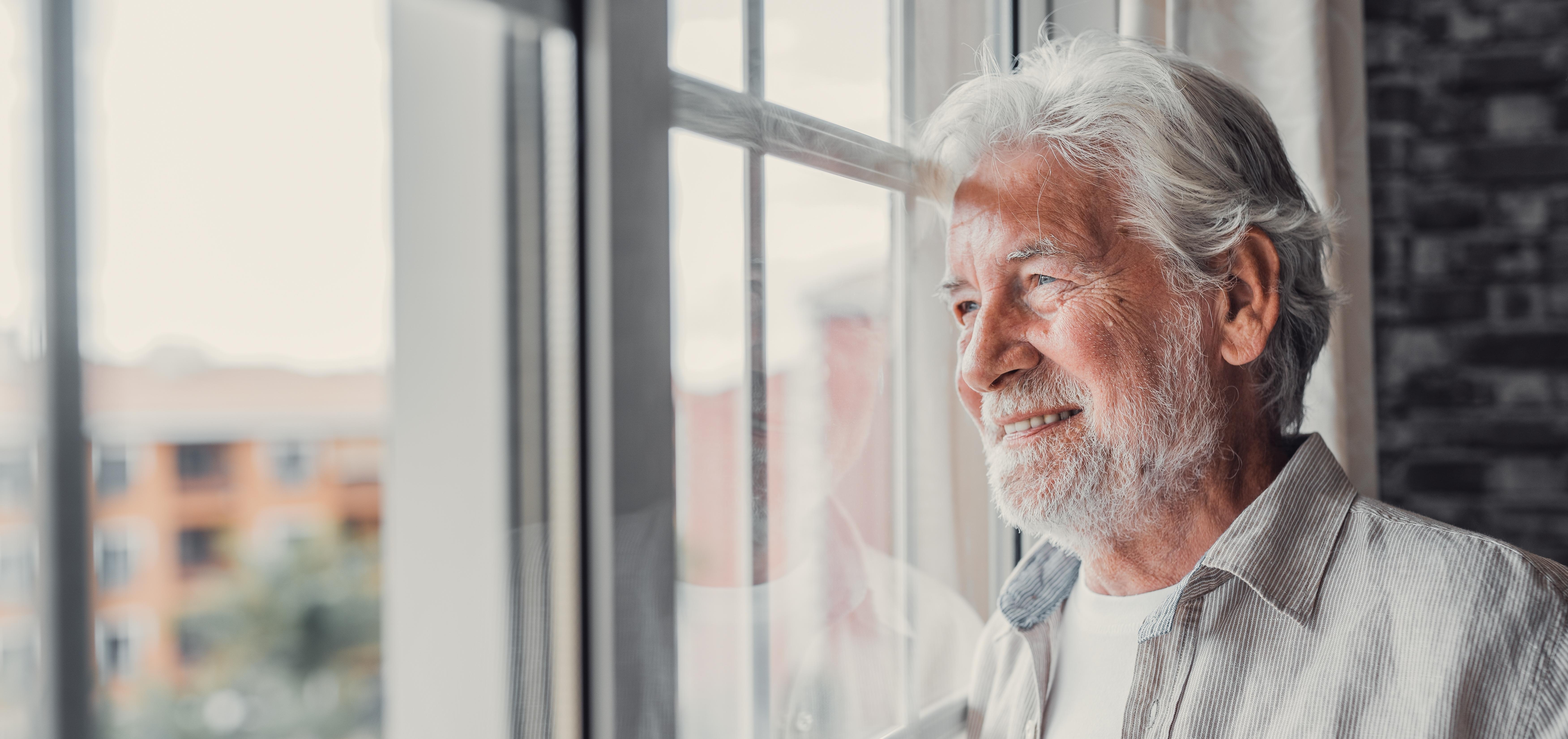 older man looking out window