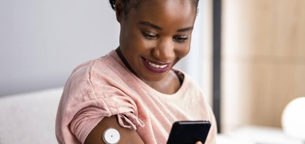 woman with diabetes checking her time in range on her mobile device
