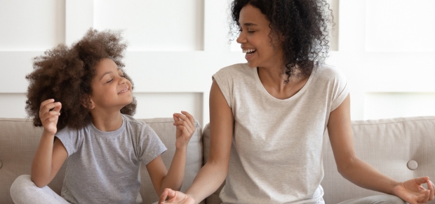 mother and daughter practicing mindfulness on couch