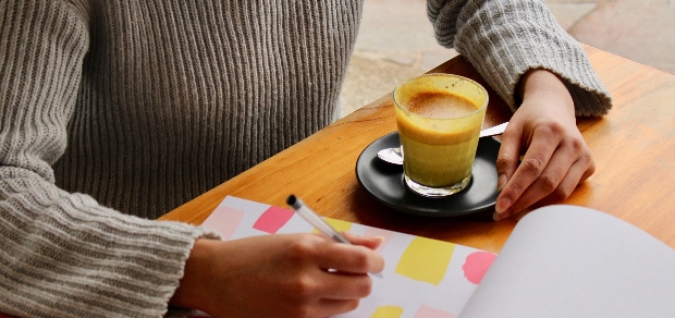 woman with a drink and a journal